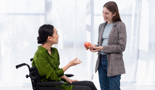 A friendly support worker from Dignity Support Services, an NDIS SIL provider in Melbourne, having a conversation with a client. 